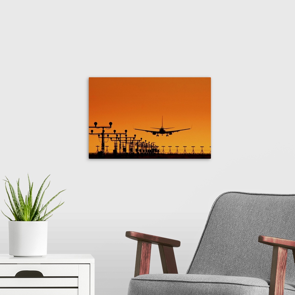 A modern room featuring Landing of an airplane at sunset