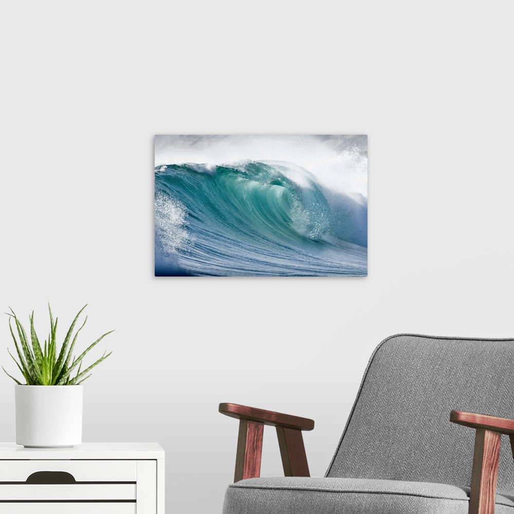 A modern room featuring Up close photograph of huge swell crashing and creating sea foam and spray.