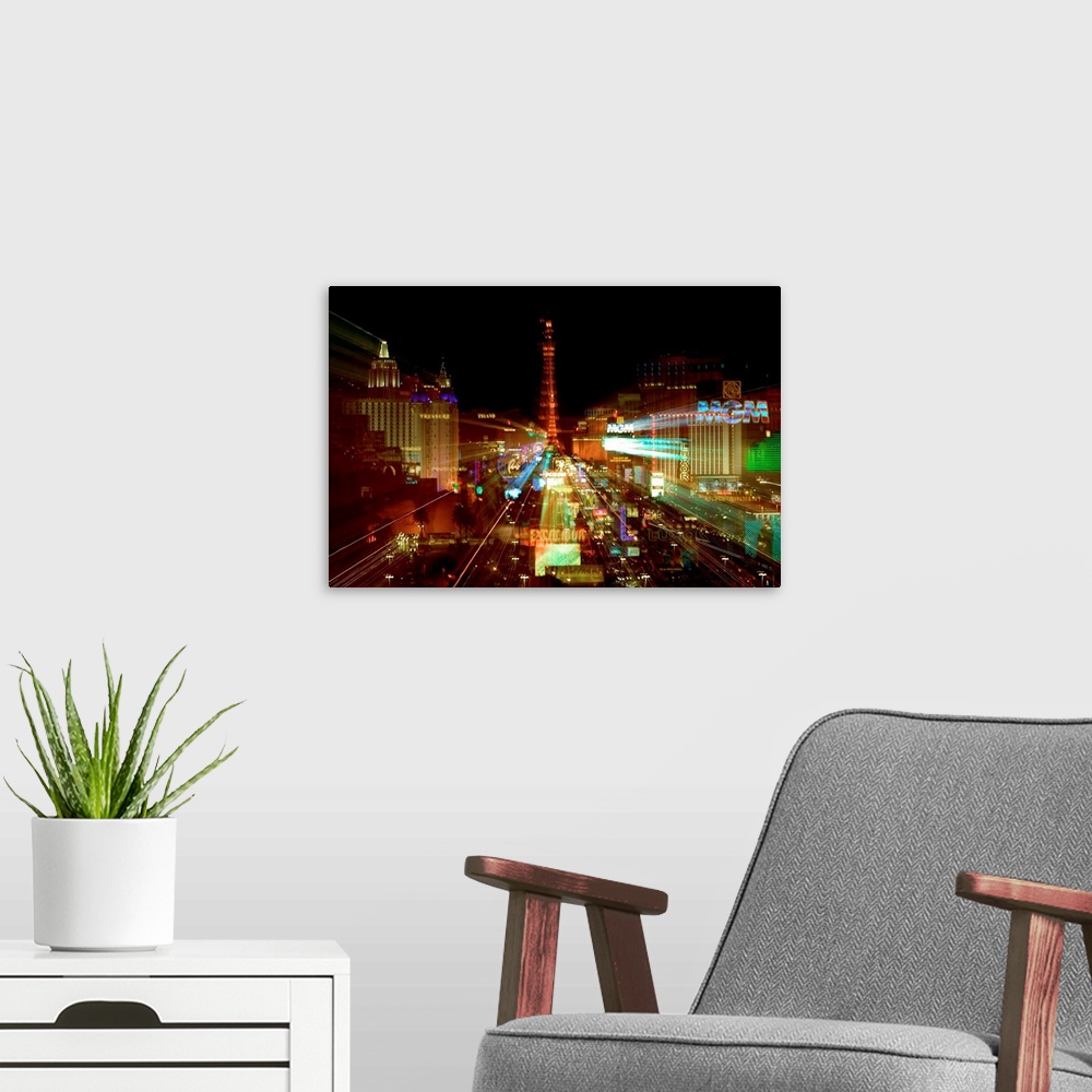 A modern room featuring This cityscape wall hanging is a time-lapsed photograph of the neon lights with the casino magnif...