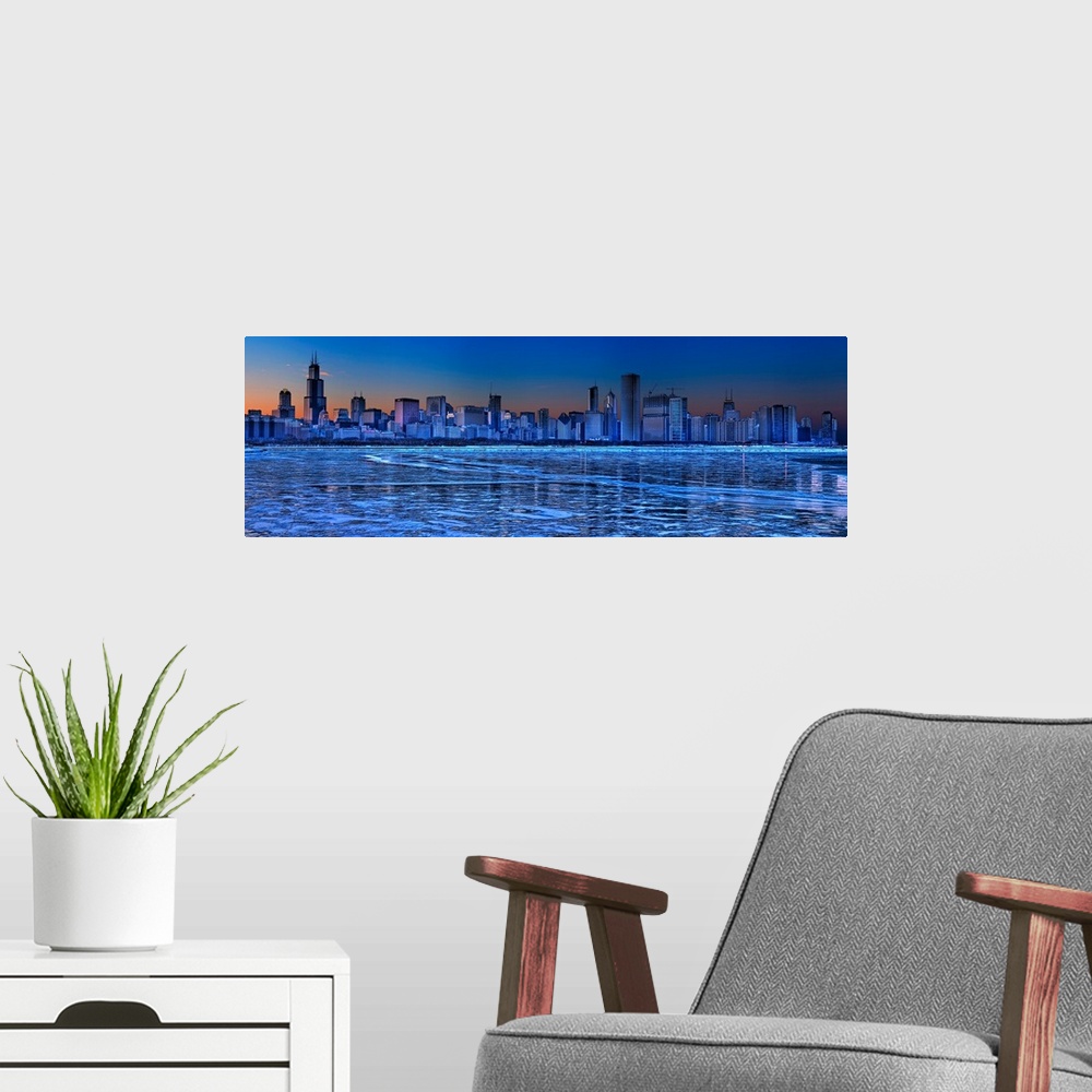 A modern room featuring Large, landscape photograph of the icy waters of Lake Michigan in front of the Chicago skyline at...