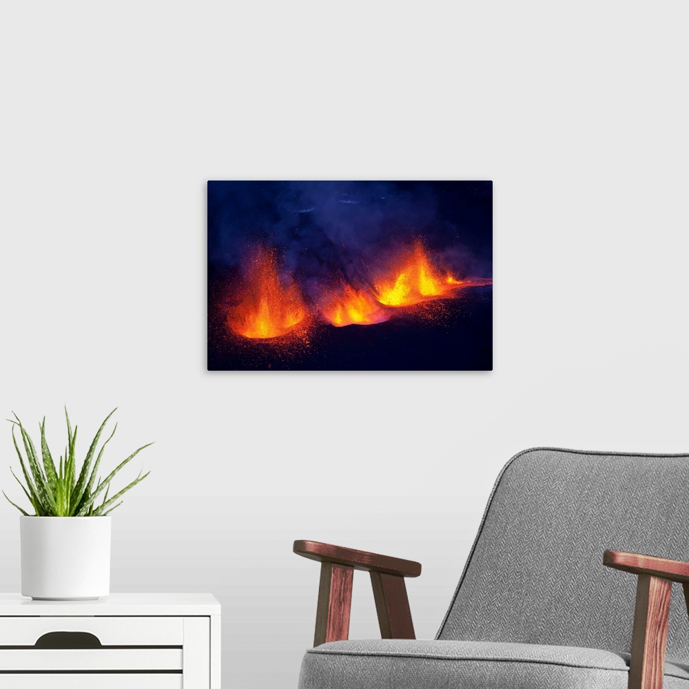A modern room featuring Lava fountains spurting during volcano eruption in Iceland at Fimmvorduhals, a ridge between Eyja...