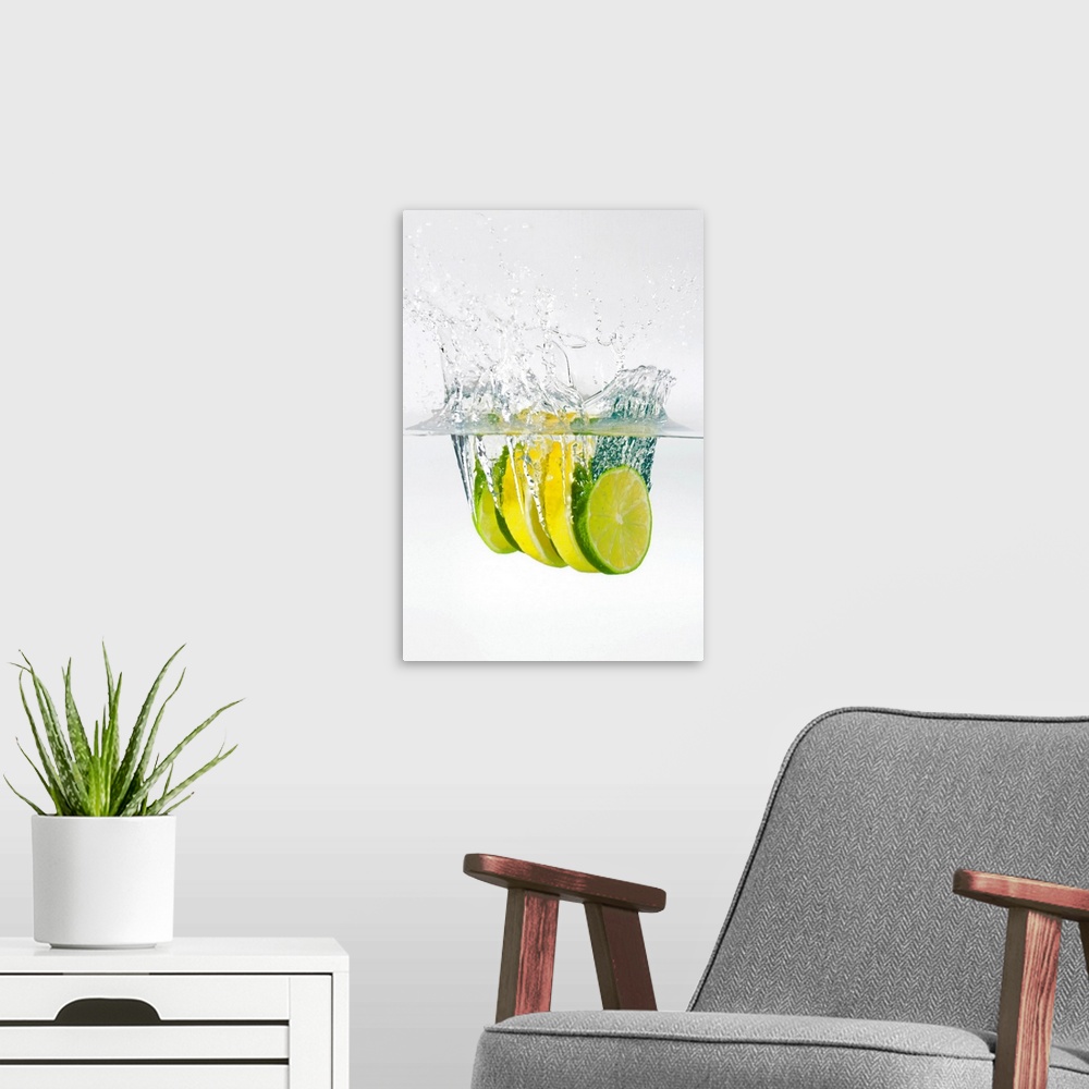 A modern room featuring Huge photograph displays four slices of fruit as they splash into water.