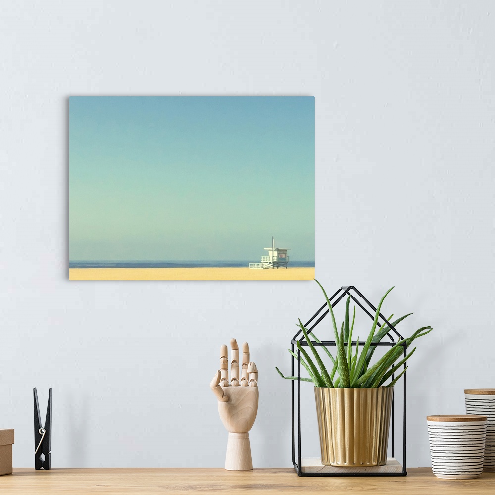 A bohemian room featuring Landscape, oversized photograph of a single lifeguard tower on an empty beach of golden sand, ben...