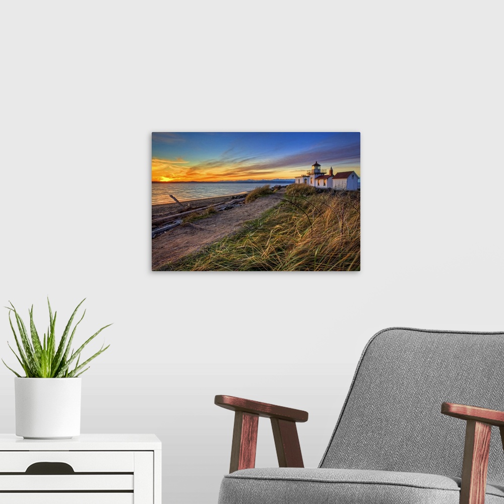 A modern room featuring Oversized, landscape, angled photograph of a coastline in Washington at sunset, with a lighthouse...
