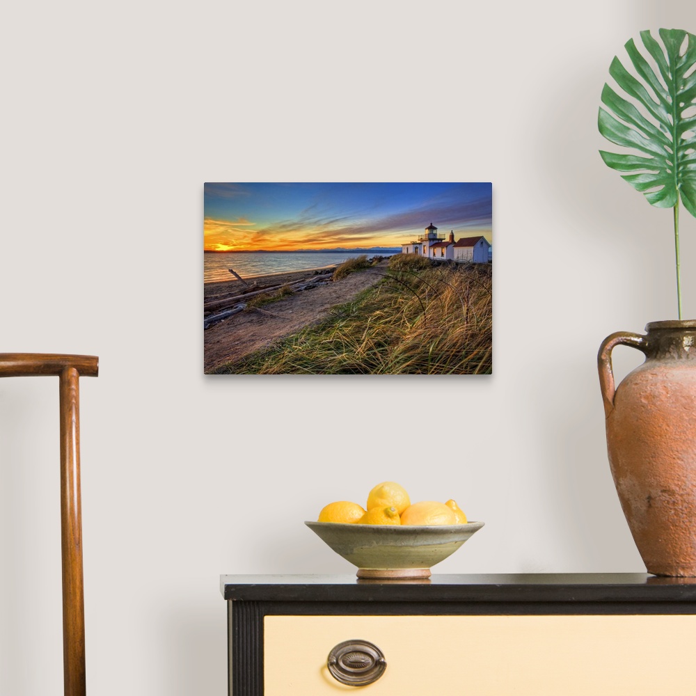 A traditional room featuring Oversized, landscape, angled photograph of a coastline in Washington at sunset, with a lighthouse...