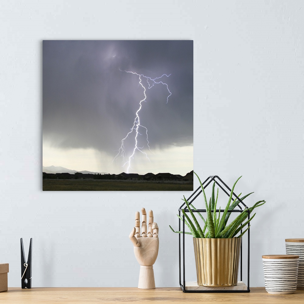 A bohemian room featuring Lightning strike sky over residential neighborhood.