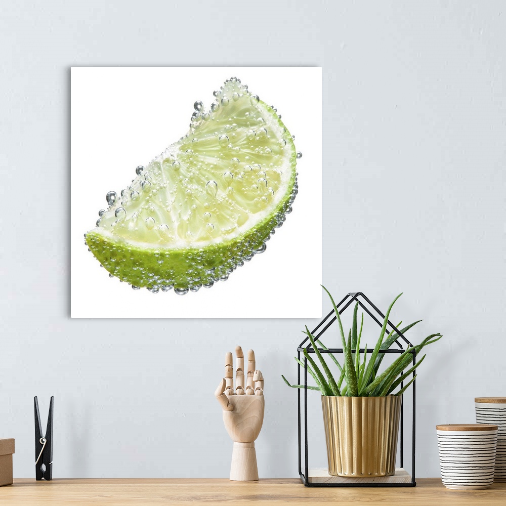 A bohemian room featuring A juicy ripe organic lime wedge fruit submerged in clean clear refreshing water and covered in bu...