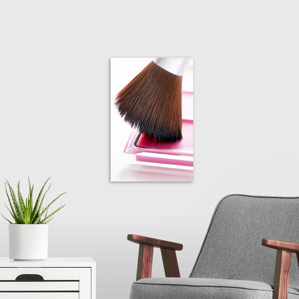 A modern room featuring Lip brush on pink lip gloss in palette, close-up