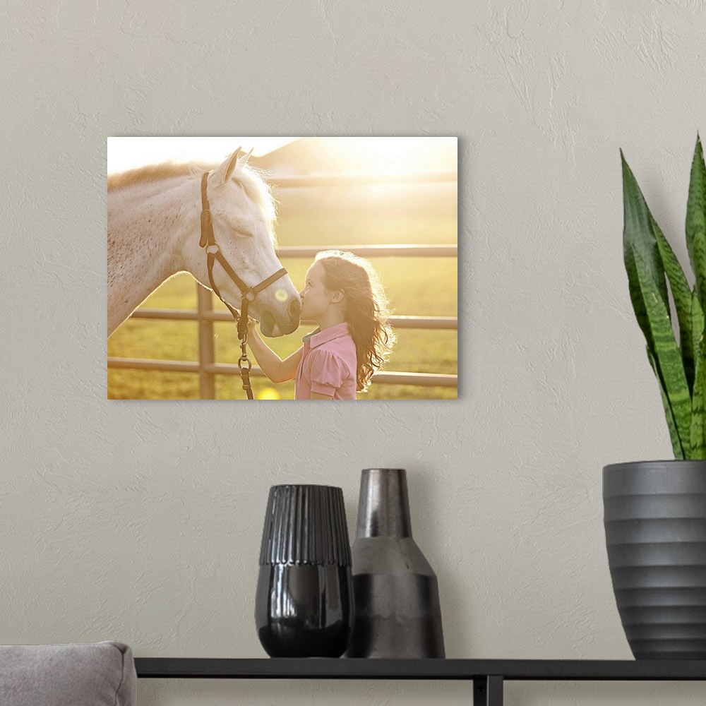 A modern room featuring A little girl at sunset kissing her horse on the nose, while horse has its eyes closed