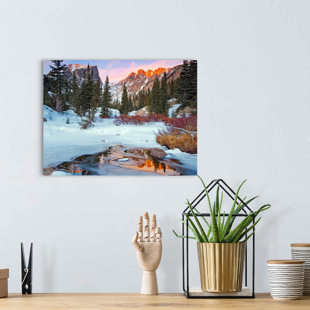 A bohemian room featuring Photograph of a little creek by snow-covered ground and trees with the Rocky Mountains in the bac...