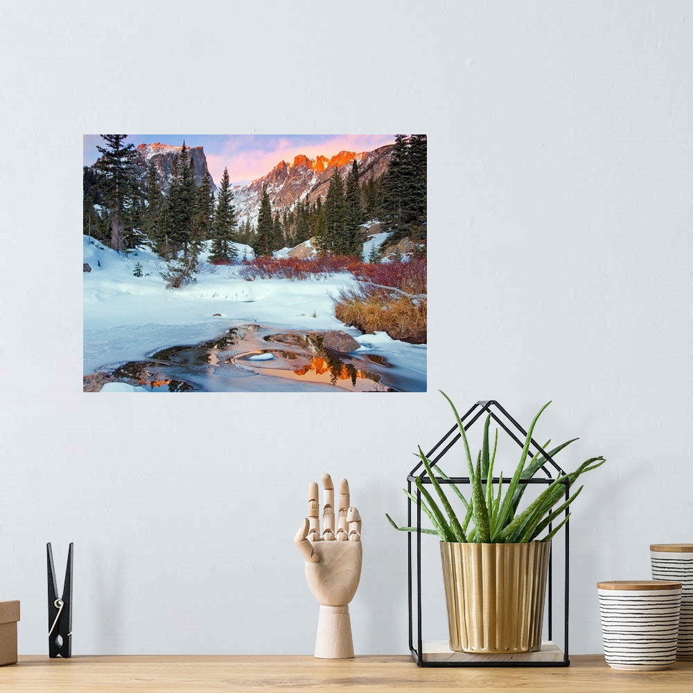 A bohemian room featuring Photograph of a little creek by snow-covered ground and trees with the Rocky Mountains in the bac...