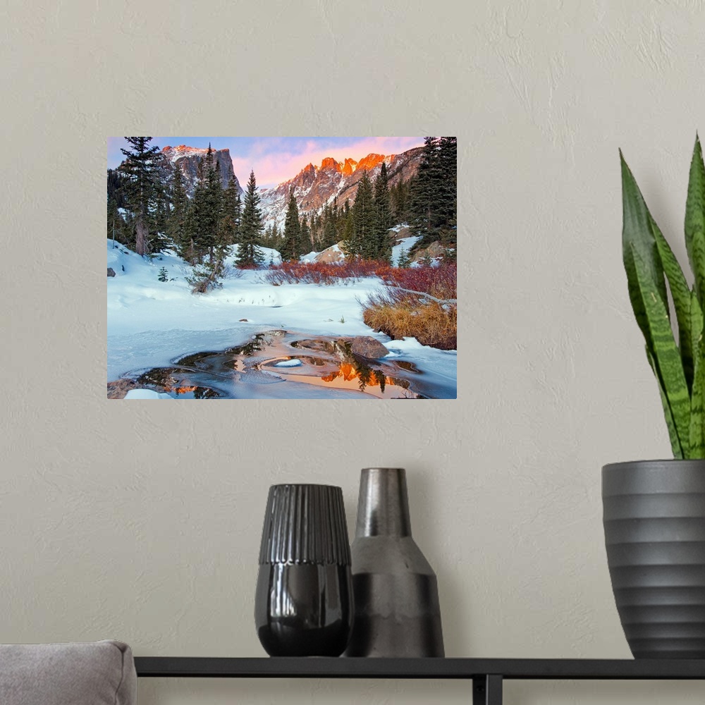 A modern room featuring Photograph of a little creek by snow-covered ground and trees with the Rocky Mountains in the bac...
