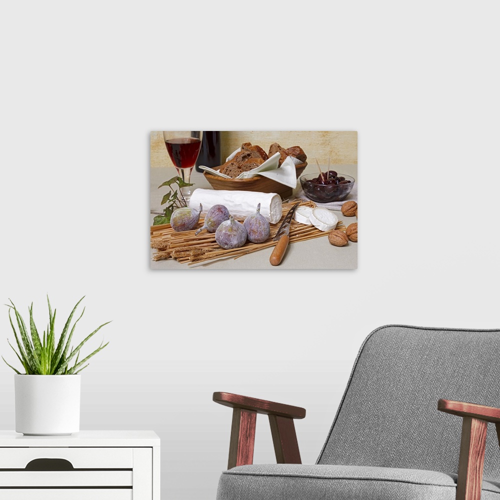 A modern room featuring Log of goat's cheese with figs, nuts, olives, bread and red wine