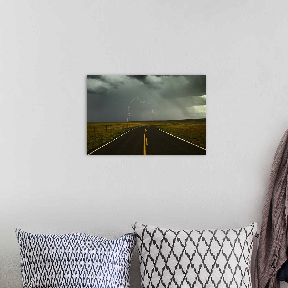 A bohemian room featuring Long and winding road against lighting strike in sky in Santa Fe Trail, Watrous, New Mexico.