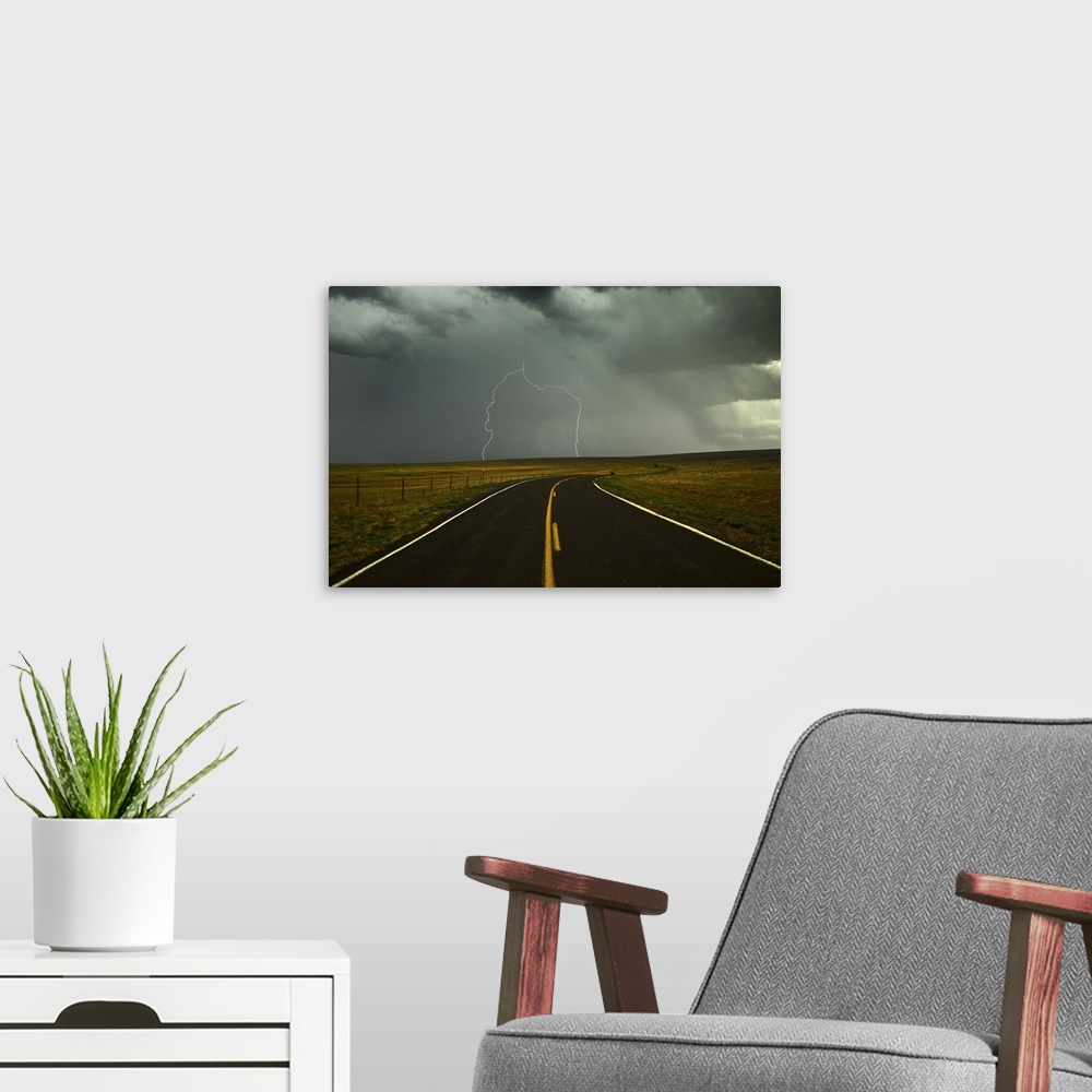 A modern room featuring Long and winding road against lighting strike in sky in Santa Fe Trail, Watrous, New Mexico.
