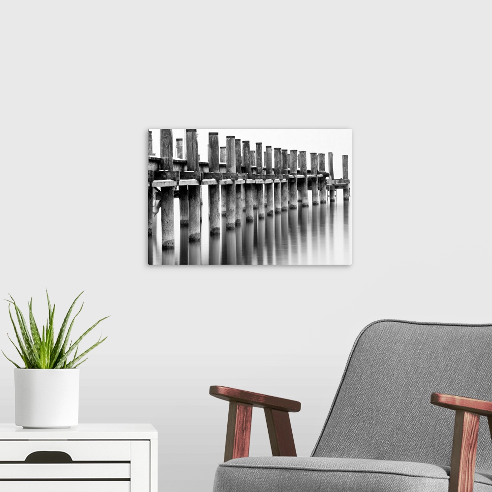 A modern room featuring Long-exposure image of pier with reflection in calm water at lake Chiemsee in Bavaria, Germany.