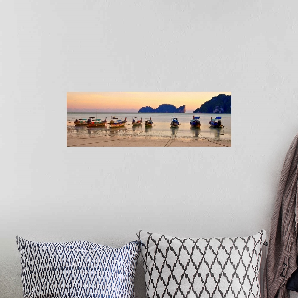 A bohemian room featuring Long tail boats on beach at sunset.