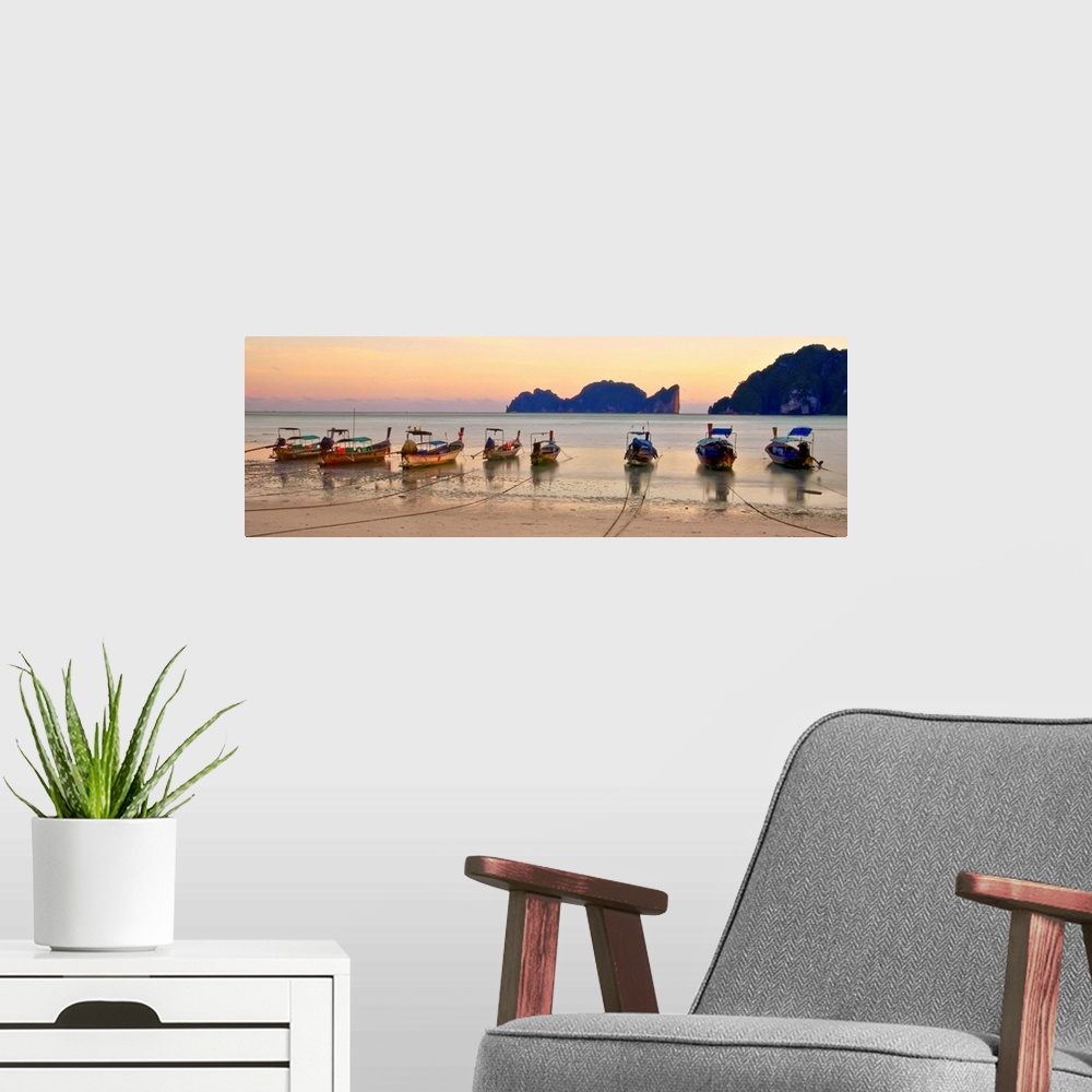 A modern room featuring Long tail boats on beach at sunset.
