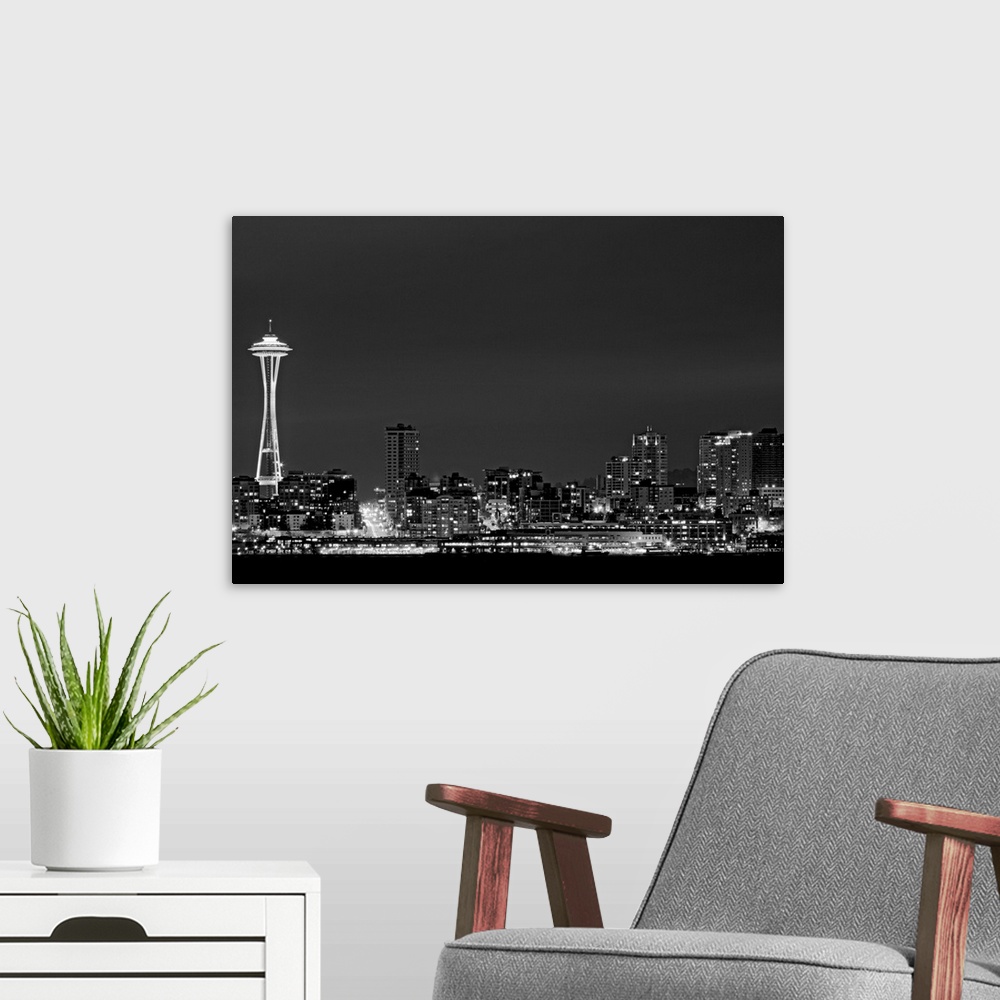 A modern room featuring Black and white photograph taken of the city skyline in Seattle with the city illuminated under a...