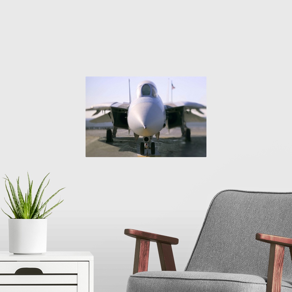 A modern room featuring Looking straight on at the nose of an F-14 military aircraft at the airport.