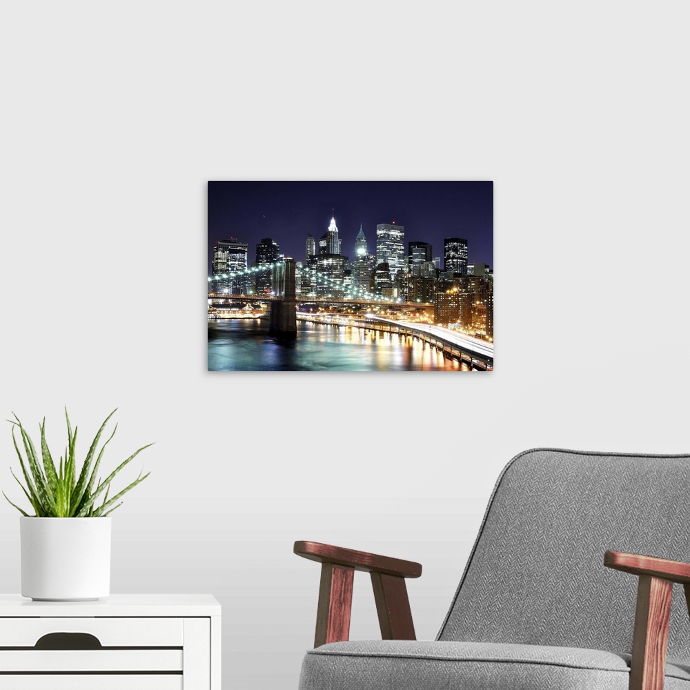 A modern room featuring Aerial view of lower Manhattan including the financial district and the Brooklyn Bridge at night.