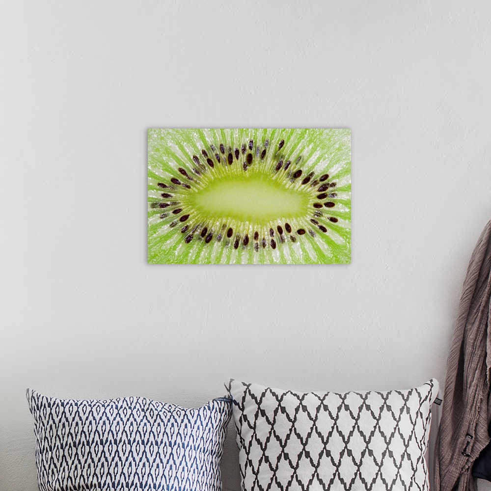 A bohemian room featuring Large closeup photograph of the inside of a sliced kiwi fruit.