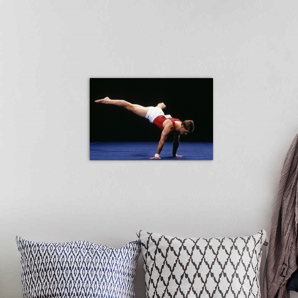 A bohemian room featuring Male gymnast peforming a routine in the floor exercise