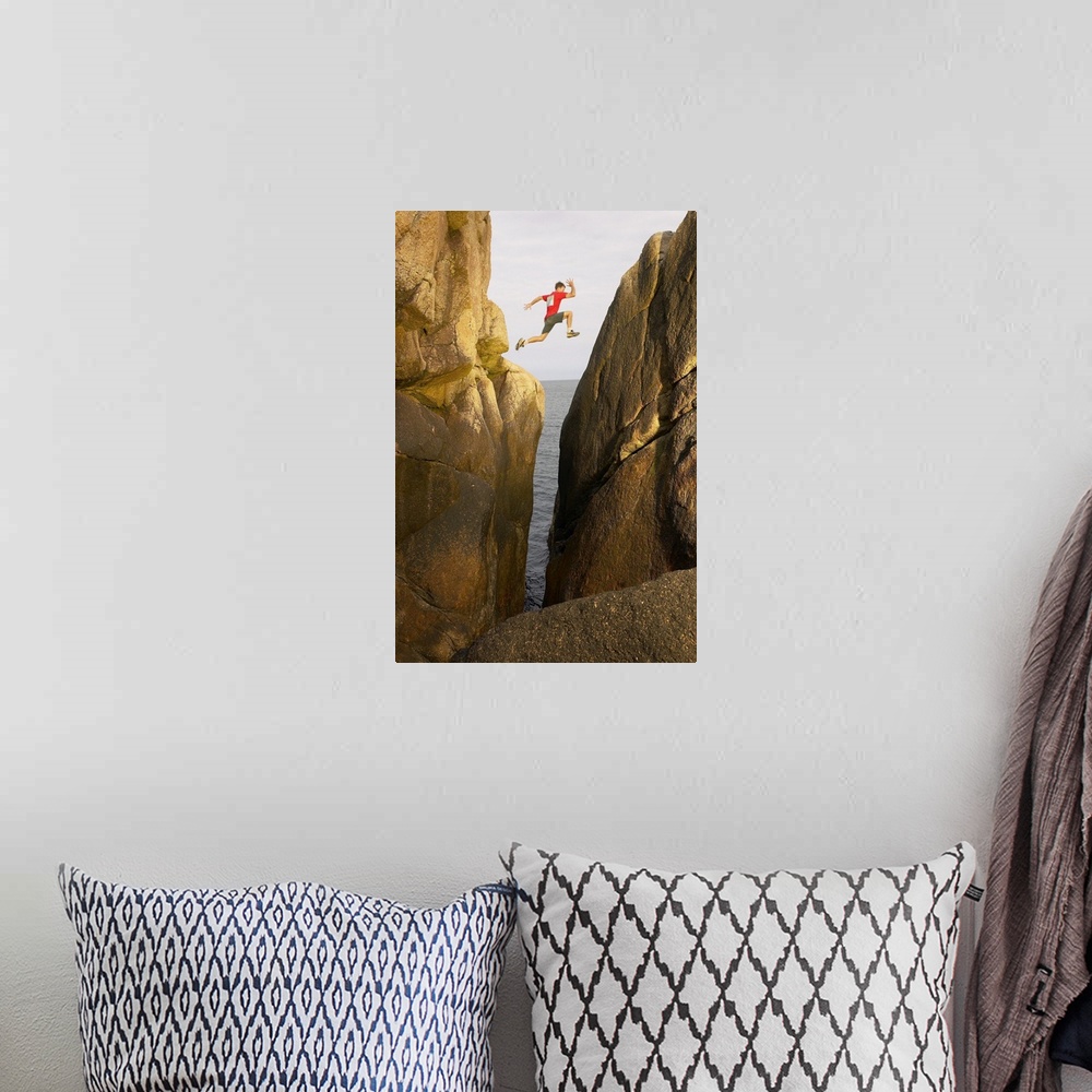 A bohemian room featuring Man leaping over rocky crevice