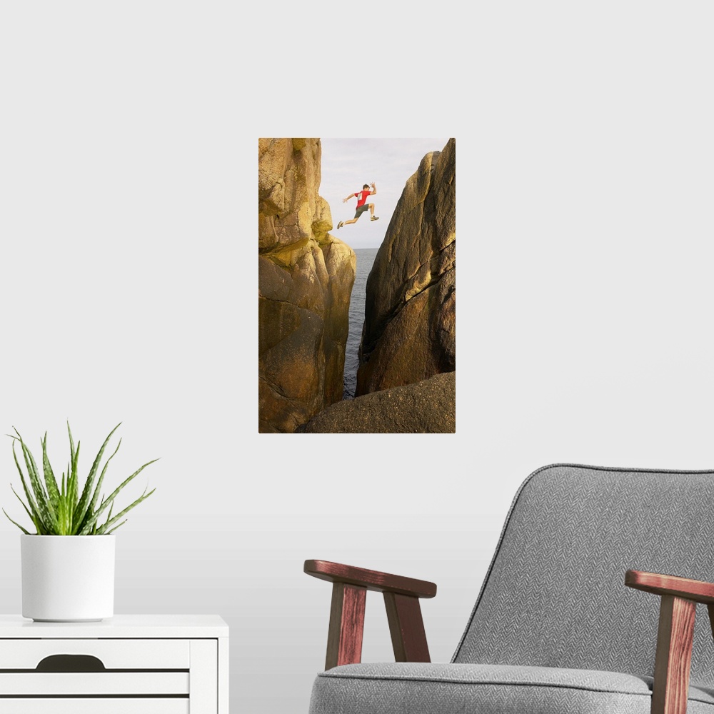 A modern room featuring Man leaping over rocky crevice