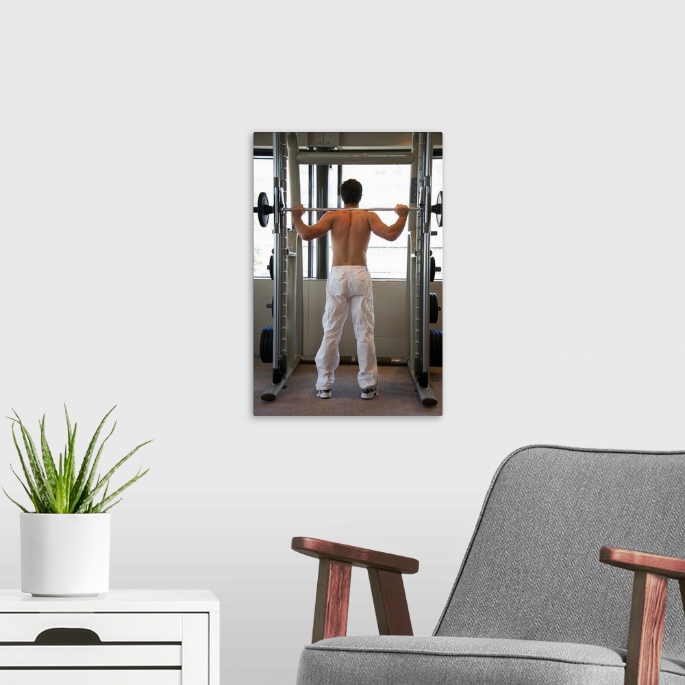 A modern room featuring Man lifting barbell