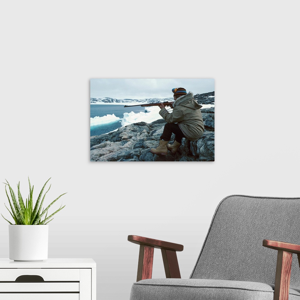 A modern room featuring Man sitting on seashore hunting