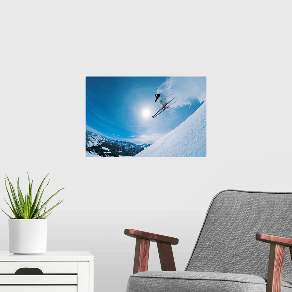 A modern room featuring Horizontal, photograph on large canvas of a skier making a jump down an angled slope, in mid-air,...