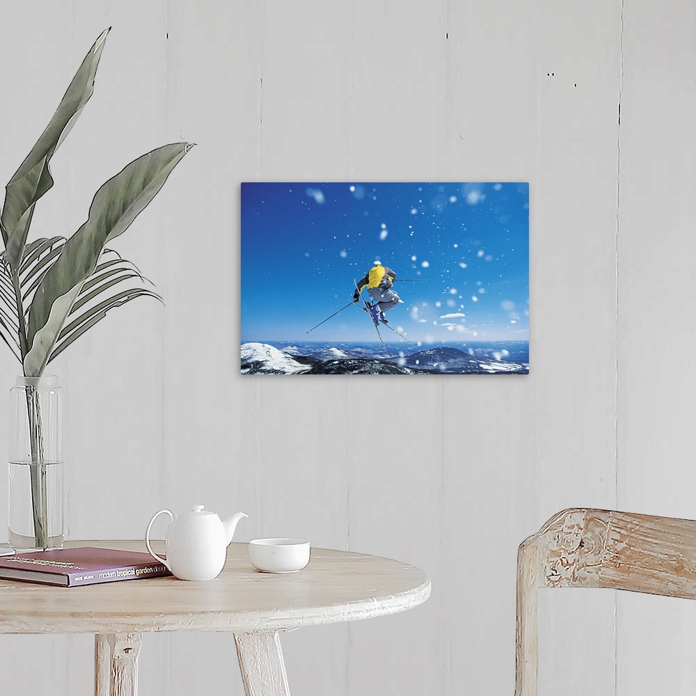 A farmhouse room featuring Photograph of man on skis in mid air jump over snow covered mountains.