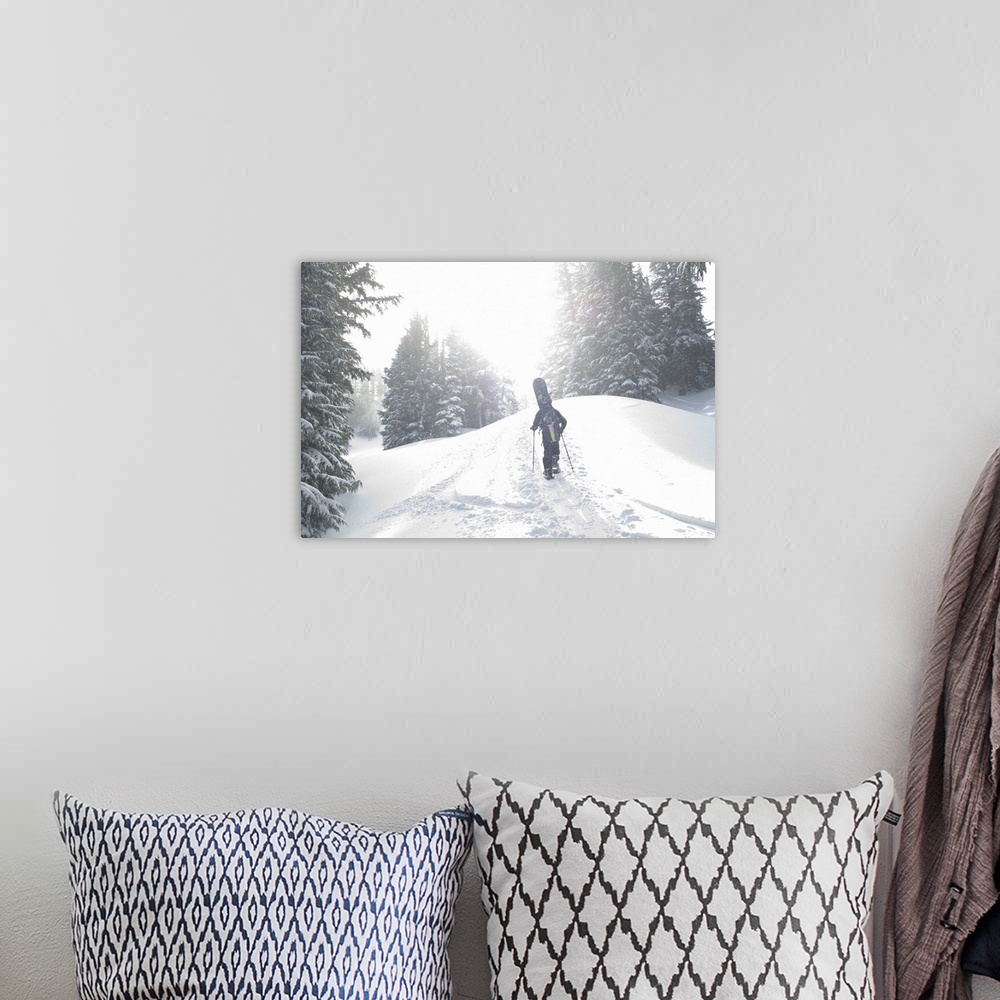 A bohemian room featuring Man with snowboard hiking up mountain