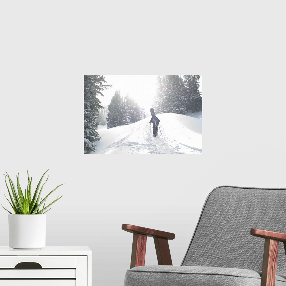 A modern room featuring Man with snowboard hiking up mountain
