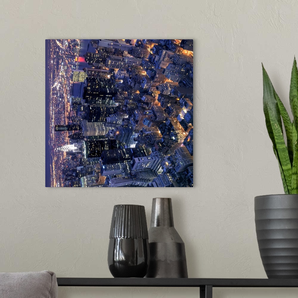 A modern room featuring New York, the city that never sleeps, with its streets and avenues glowing orange in the night. P...