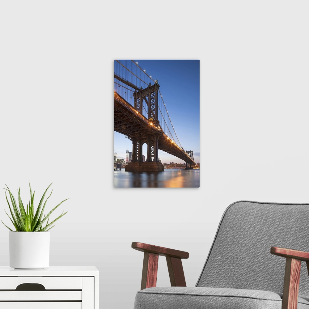A modern room featuring Manhattan Bridge and Lower East Side at dusk in New York, New York State, USA