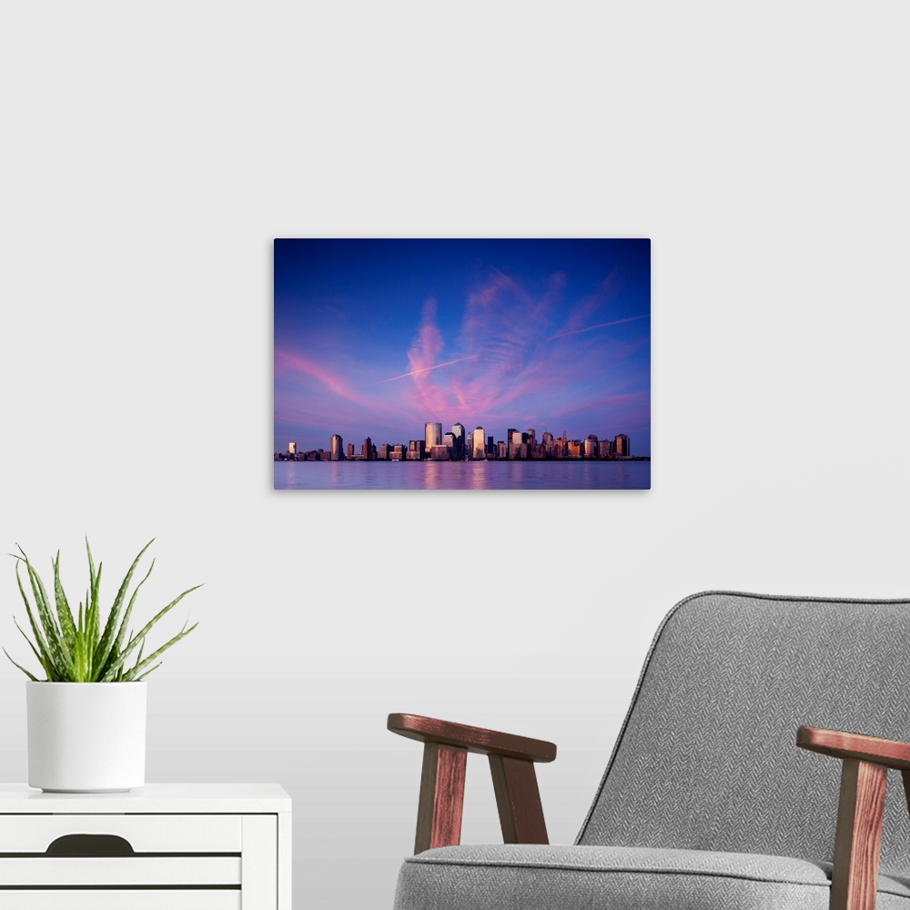 A modern room featuring USA, New York, New York City, Setting sun lights clouds above Manhattan skyline, viewed from New ...
