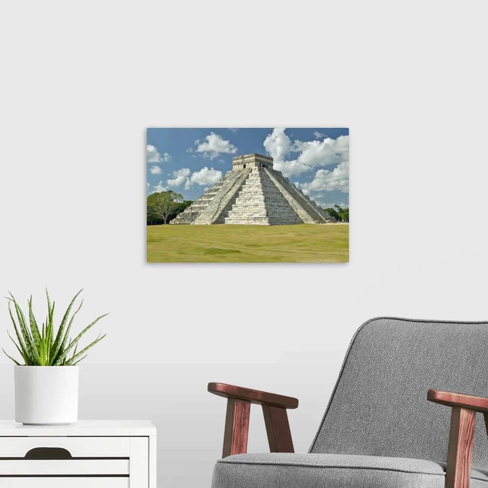 A modern room featuring White puffy clouds over the Mayan Pyramid of Kukulkan (also known as El Castillo) and ruins at Ch...