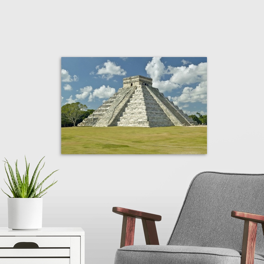A modern room featuring White puffy clouds over the Mayan Pyramid of Kukulkan (also known as El Castillo) and ruins at Ch...