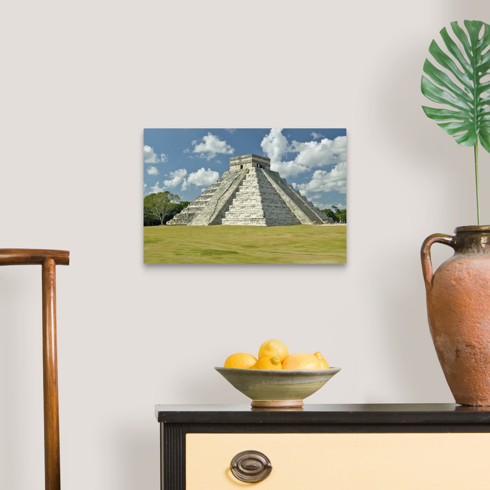A traditional room featuring White puffy clouds over the Mayan Pyramid of Kukulkan (also known as El Castillo) and ruins at Ch...