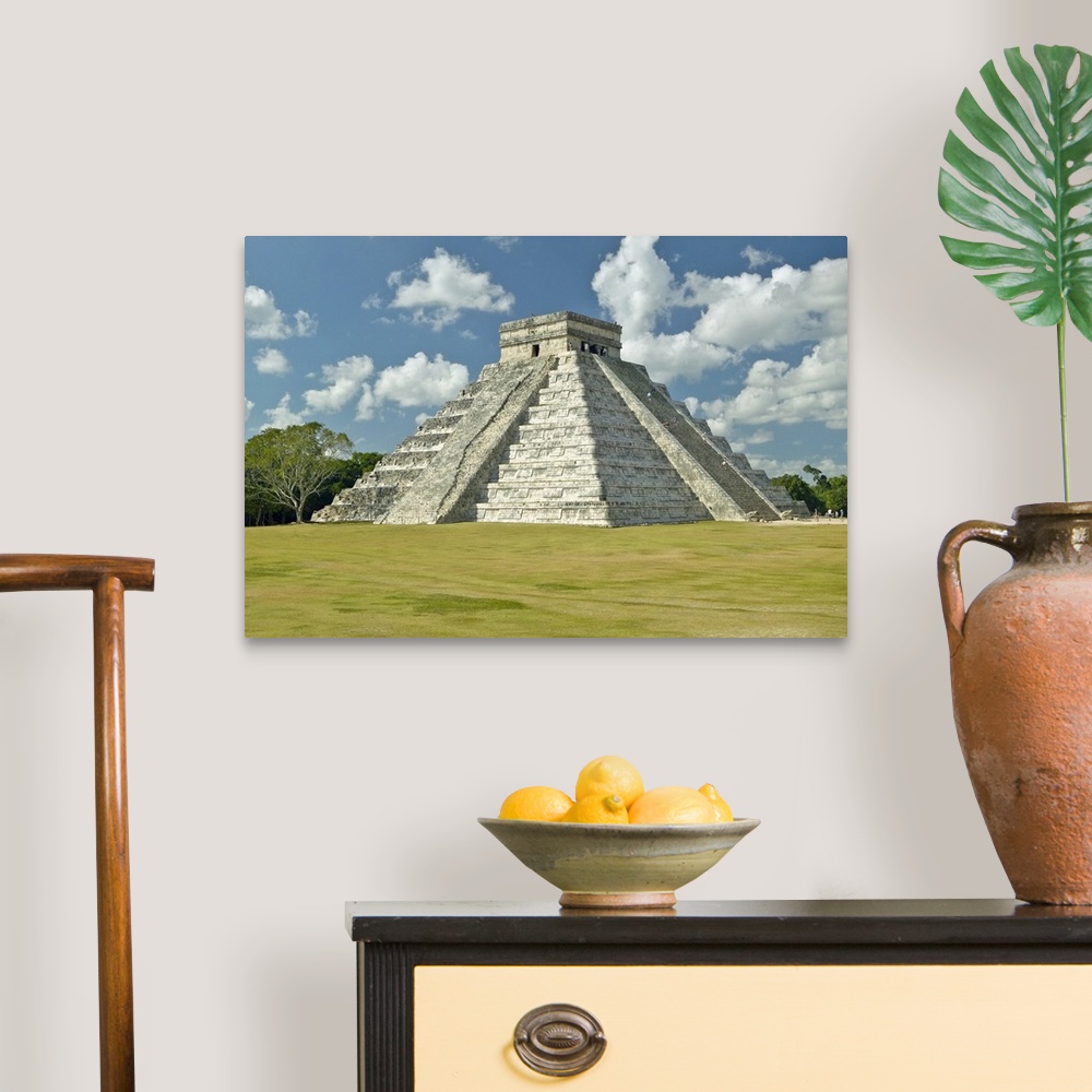 A traditional room featuring White puffy clouds over the Mayan Pyramid of Kukulkan (also known as El Castillo) and ruins at Ch...