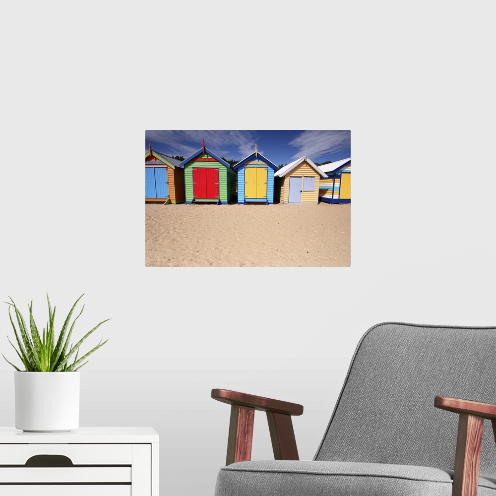 A modern room featuring Photograph of colorful shacks on the beach under a cloudy sky.