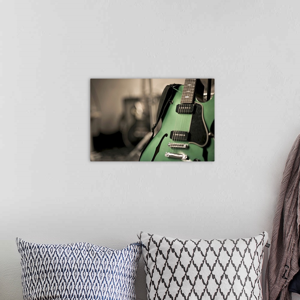 A bohemian room featuring Metallic green hollow-body electric guitar used by band Neon love life. Guitar is on stand with s...