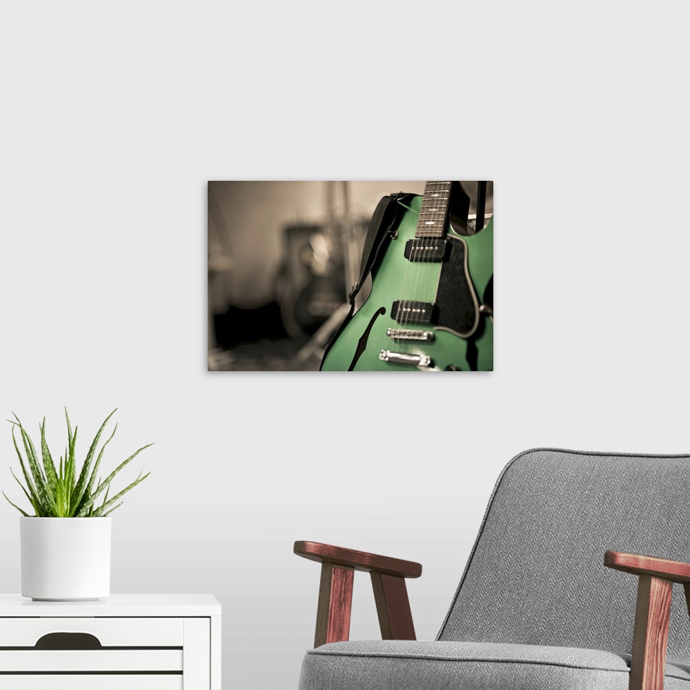 A modern room featuring Metallic green hollow-body electric guitar used by band Neon love life. Guitar is on stand with s...