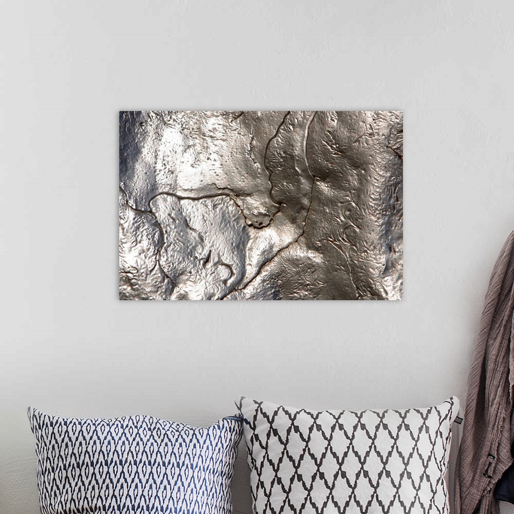 A bohemian room featuring Abstract artwork of a metallic silver object that has been photographed close up.