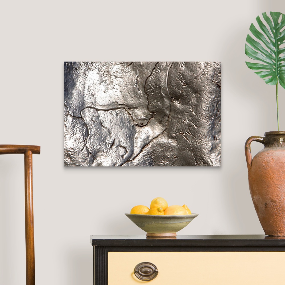 A traditional room featuring Abstract artwork of a metallic silver object that has been photographed close up.