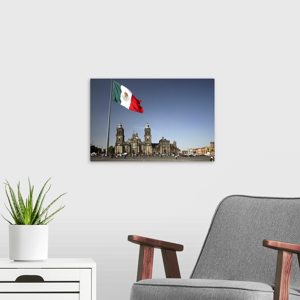A modern room featuring Mexico City cathedral framed under the huge flag, at the Zocalo square, also called Plaza de la C...
