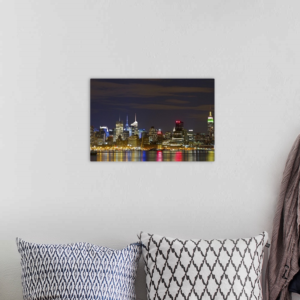 A bohemian room featuring Giant landscape photograph of the brightly lit Manhattan skyline at night, reflecting in the water.