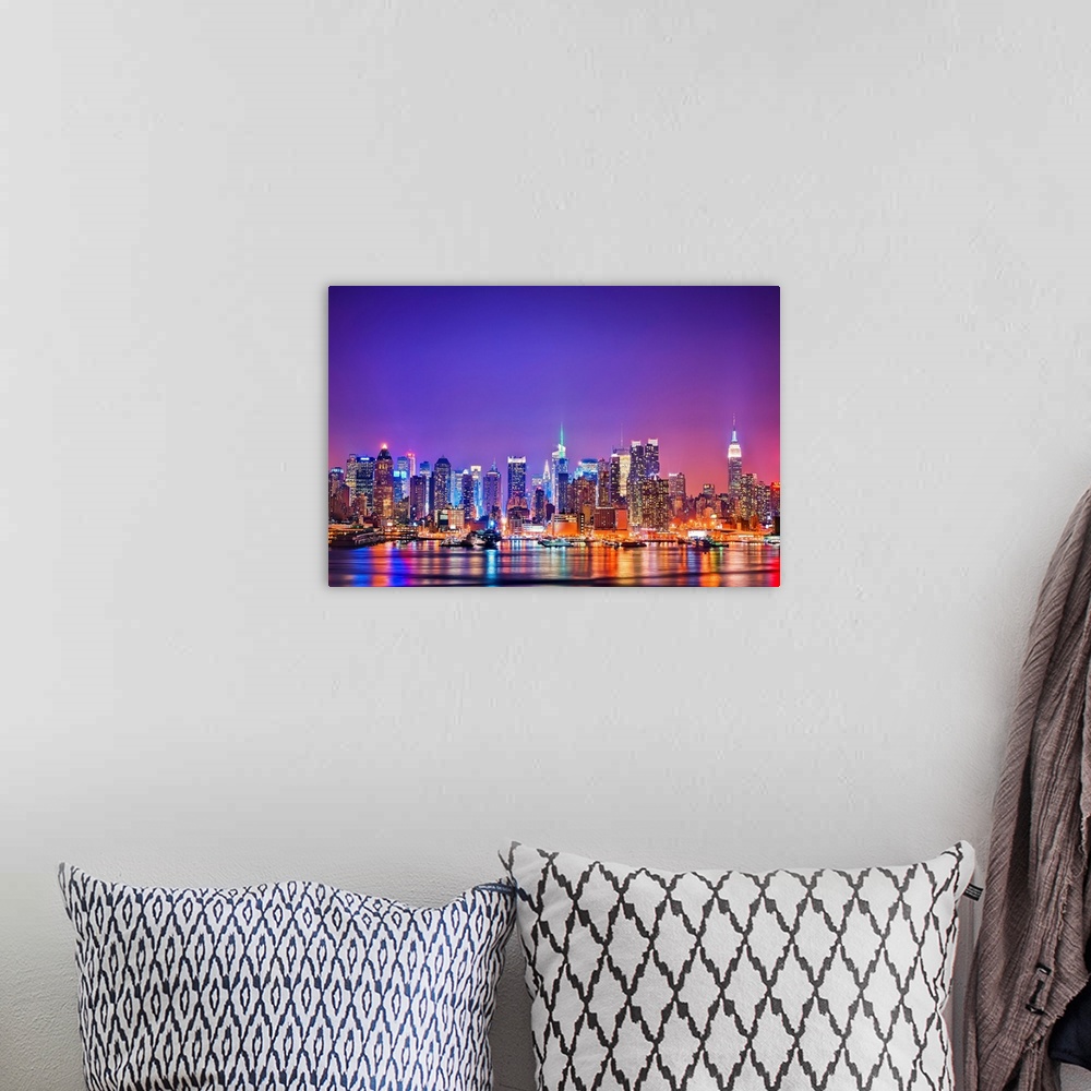 A bohemian room featuring Photograph of New York skyline at night with the Hudson River in foreground.  The building lights...